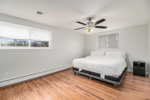 bedroom with a baseboard radiator, light hardwood / wood-style floors, and ceiling fan