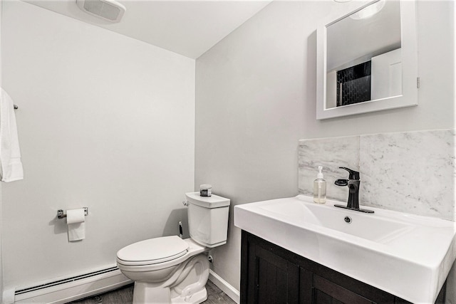 bathroom with vanity, baseboard heating, and toilet