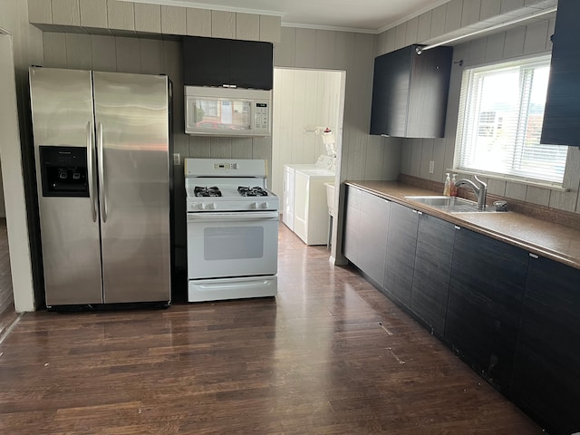 kitchen with sink, washing machine and dryer, dark hardwood / wood-style flooring, crown molding, and white appliances