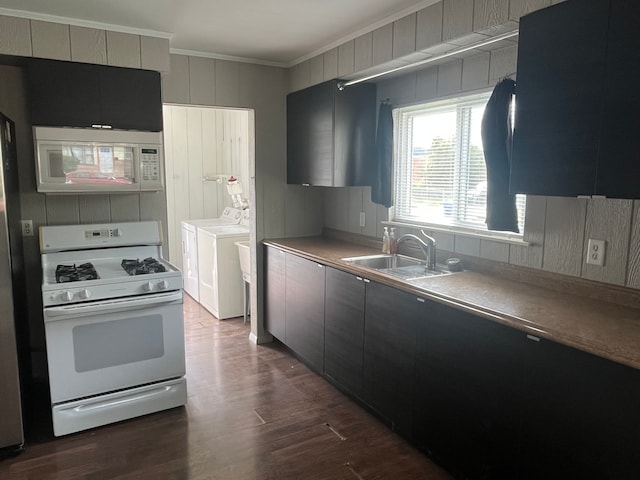 kitchen featuring white appliances, sink, dark hardwood / wood-style floors, ornamental molding, and washing machine and clothes dryer