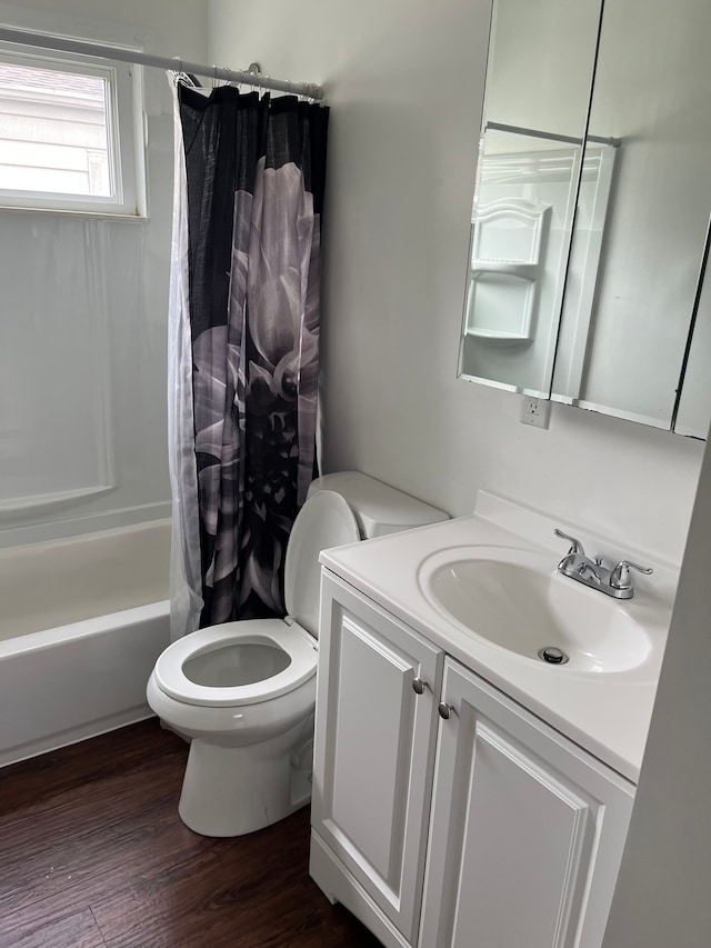 full bathroom featuring toilet, hardwood / wood-style floors, vanity, and shower / tub combo with curtain