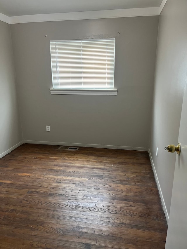 unfurnished room with crown molding and dark wood-type flooring