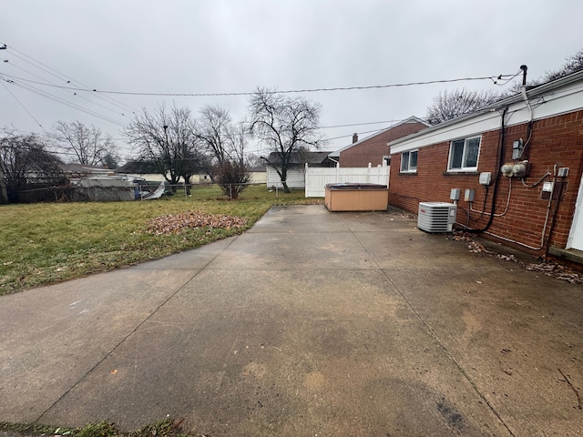 view of property exterior with central AC unit, a patio, a lawn, and a hot tub