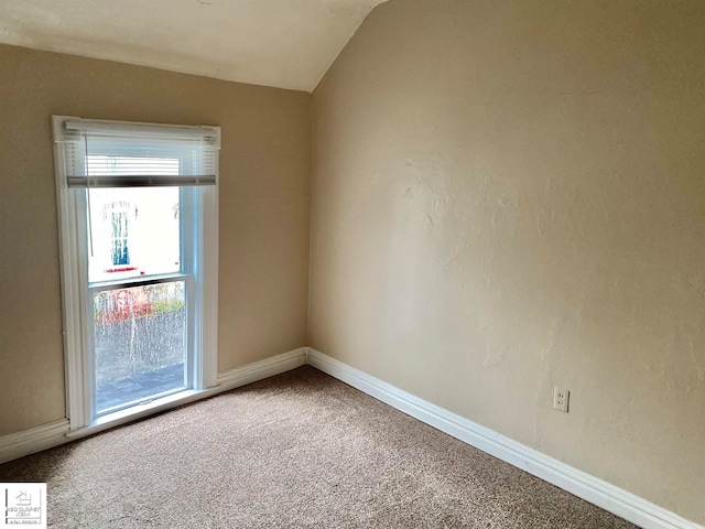 empty room with carpet floors and lofted ceiling