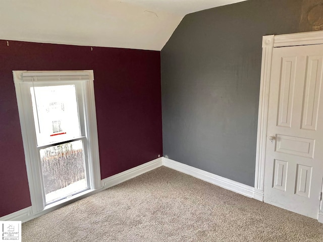 spare room with carpet and lofted ceiling