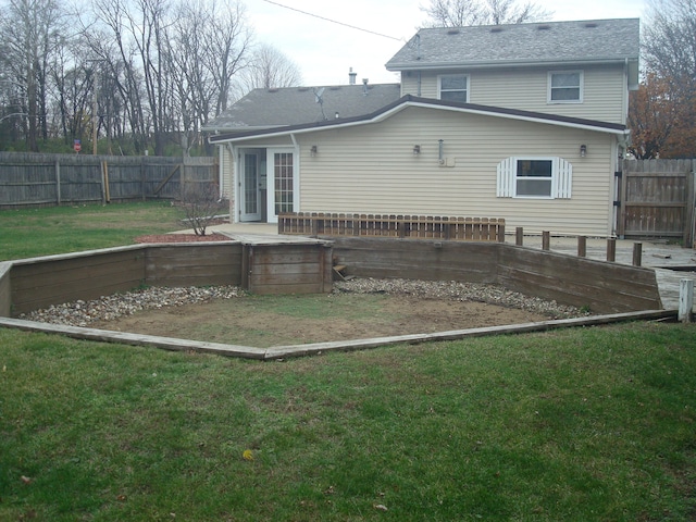 rear view of house featuring a yard