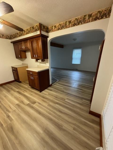 kitchen with a textured ceiling, light hardwood / wood-style flooring, and ceiling fan