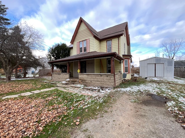 view of front facade featuring covered porch and a shed