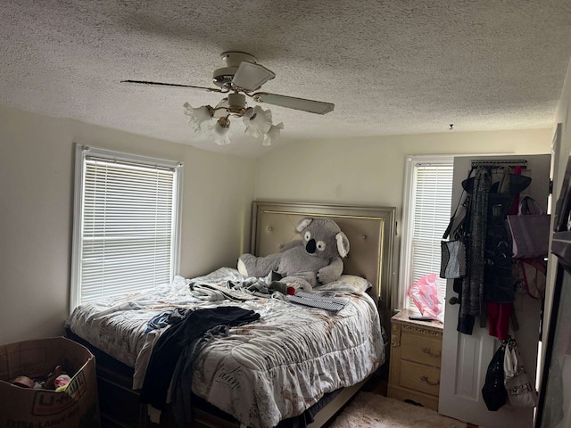 bedroom featuring lofted ceiling, ceiling fan, and a textured ceiling