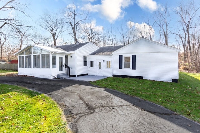 single story home with a sunroom and a front yard