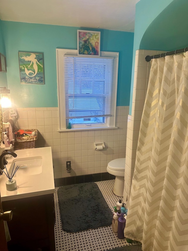 bathroom featuring tile patterned floors, vanity, tile walls, toilet, and curtained shower