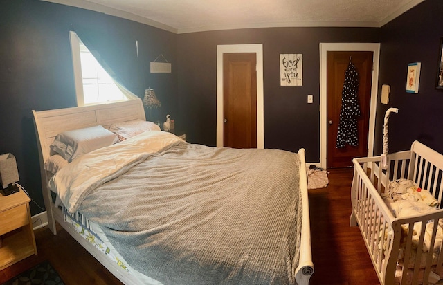 bedroom with crown molding and dark hardwood / wood-style floors