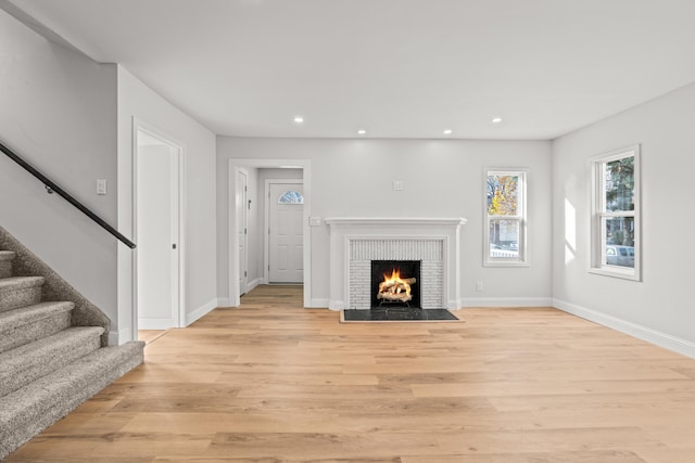 unfurnished living room featuring a fireplace and light hardwood / wood-style flooring