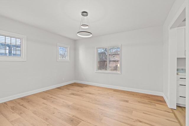 spare room with a wealth of natural light and light hardwood / wood-style flooring