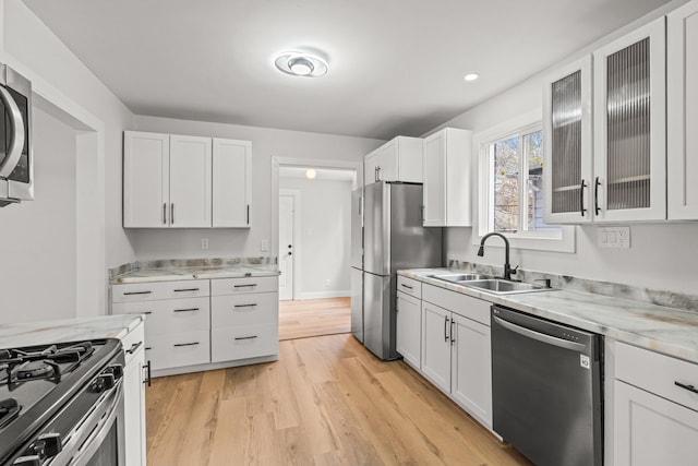 kitchen with white cabinets, appliances with stainless steel finishes, and sink