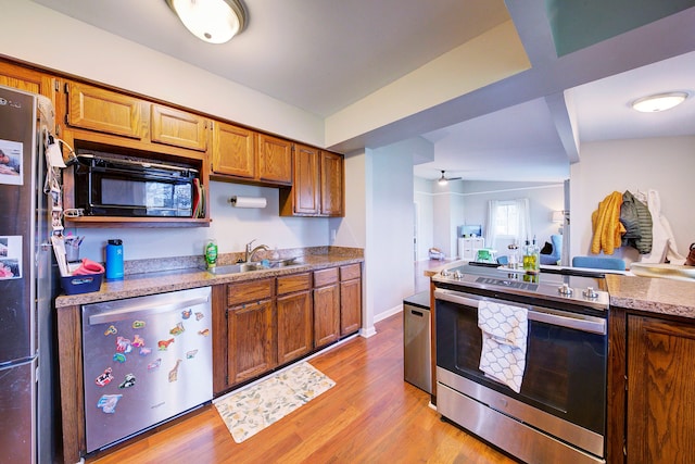 kitchen featuring sink, stainless steel appliances, lofted ceiling, and light wood-type flooring