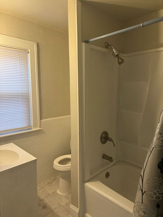 full bathroom featuring tile patterned flooring, bathing tub / shower combination, toilet, vanity, and tile walls