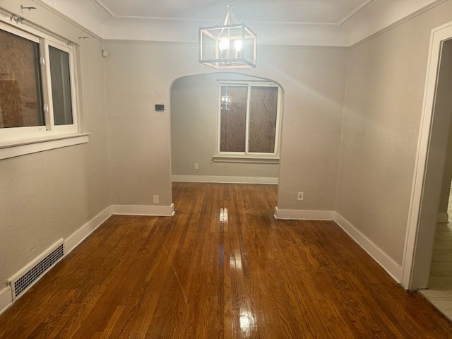 unfurnished dining area with crown molding and dark wood-type flooring