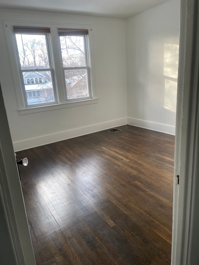 empty room with dark hardwood / wood-style flooring