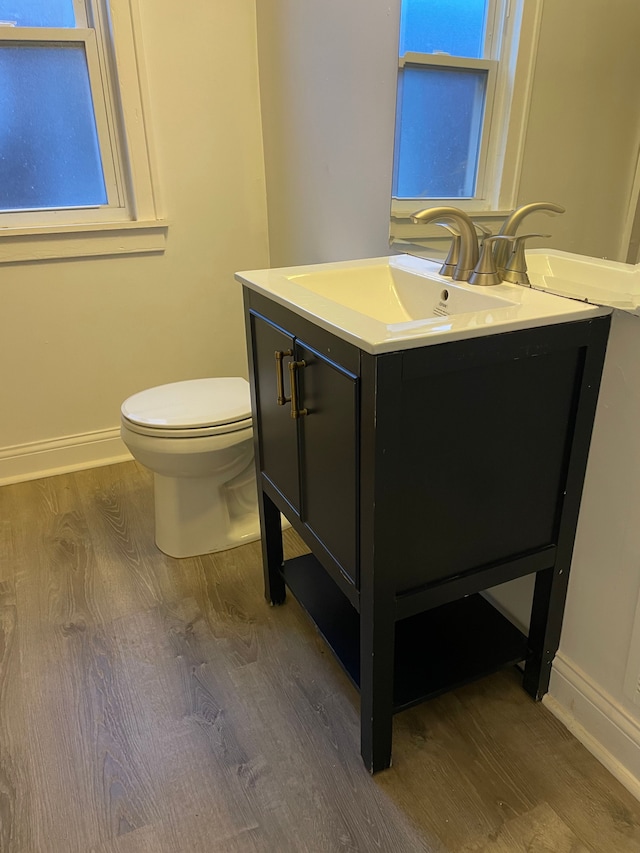 bathroom with wood-type flooring, toilet, and vanity