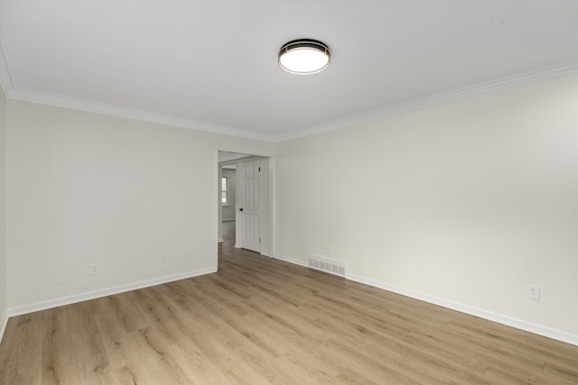 empty room featuring light hardwood / wood-style flooring and crown molding