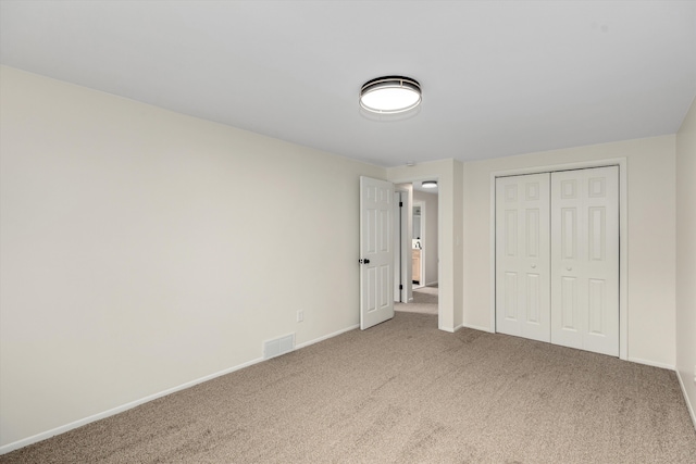 unfurnished bedroom featuring carpet flooring and a closet