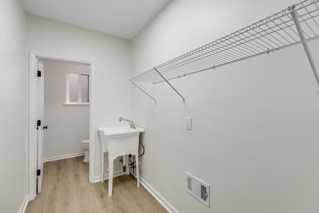 laundry room with light hardwood / wood-style floors