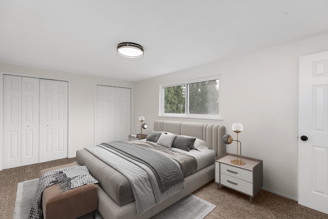 bedroom featuring dark carpet and two closets