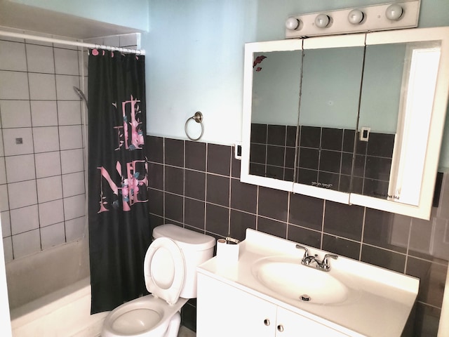 full bathroom featuring shower / tub combo with curtain, vanity, tile walls, and toilet