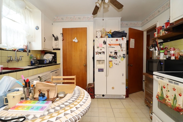 kitchen featuring tile countertops, white appliances, white cabinets, sink, and ceiling fan