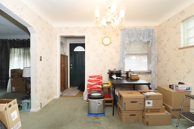 dining area featuring carpet flooring, a wealth of natural light, and an inviting chandelier