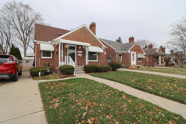 bungalow-style home with a front yard