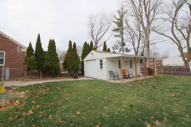 rear view of property with a patio, a yard, a garage, and an outdoor structure