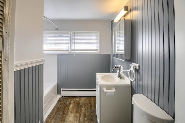 full bathroom with wood-type flooring, vanity, plenty of natural light, and a baseboard heating unit