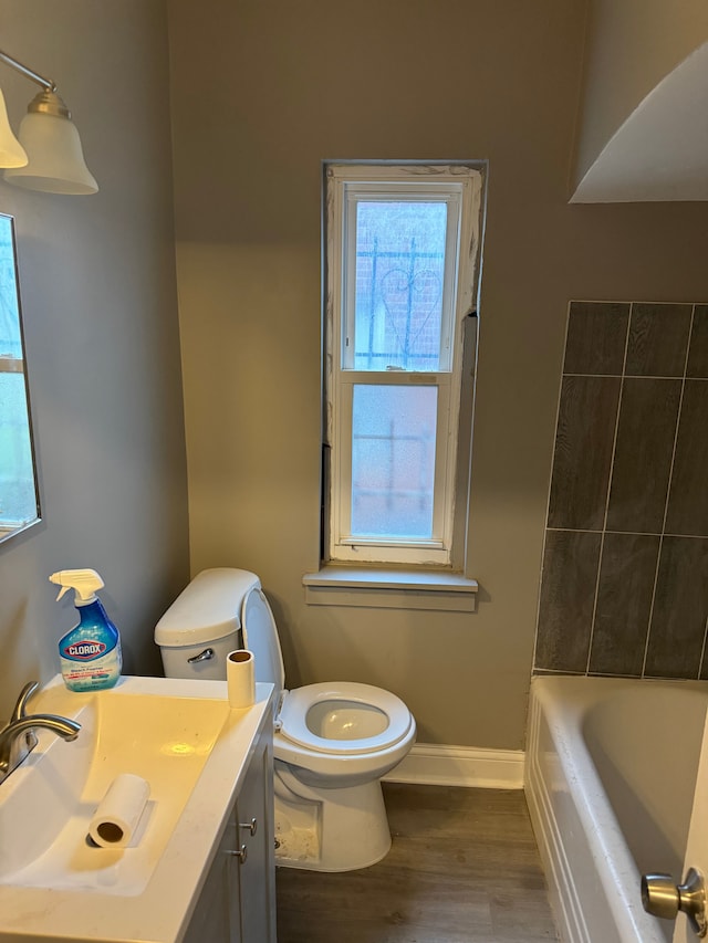 bathroom featuring plenty of natural light, vanity, hardwood / wood-style floors, and toilet