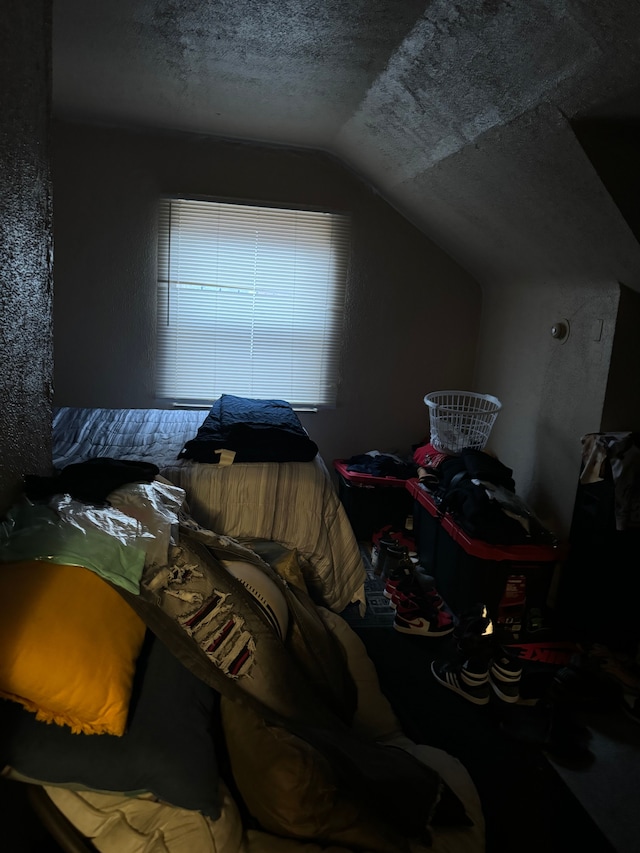 bedroom with a textured ceiling and lofted ceiling