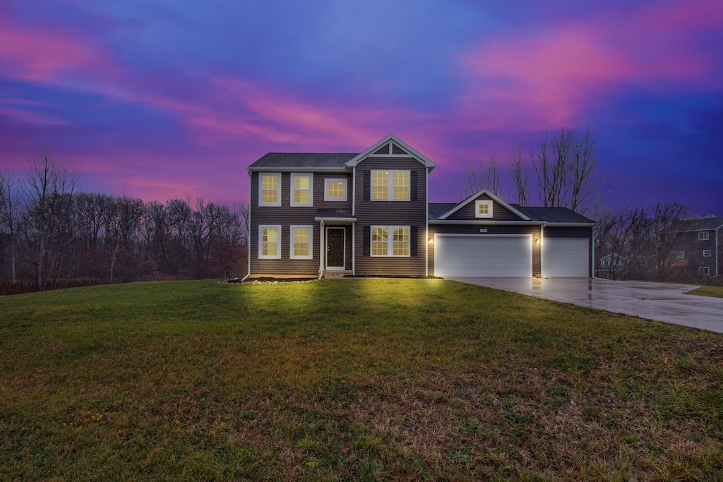 view of front of home featuring a garage and a yard