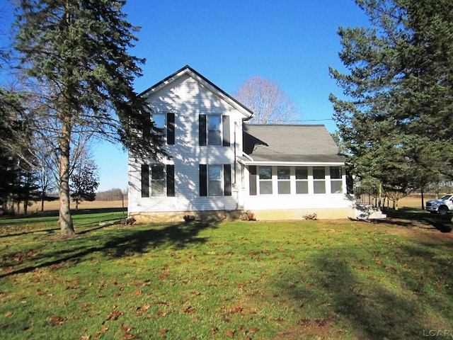 view of front of property featuring a front yard and a sunroom