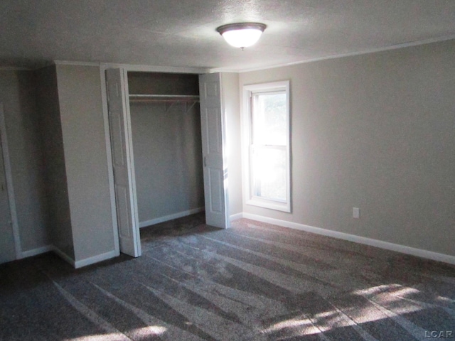 unfurnished bedroom featuring dark colored carpet and a closet