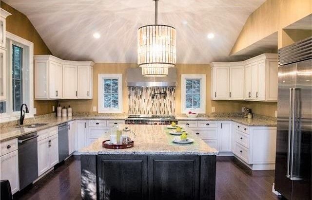 kitchen featuring a center island, an inviting chandelier, white cabinets, decorative light fixtures, and stainless steel appliances