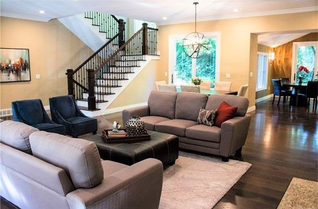 living room featuring a chandelier, ornamental molding, and dark wood-type flooring