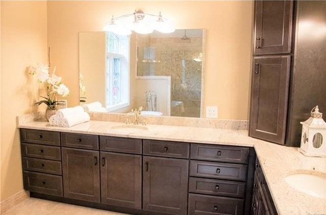 bathroom featuring a tile shower and vanity