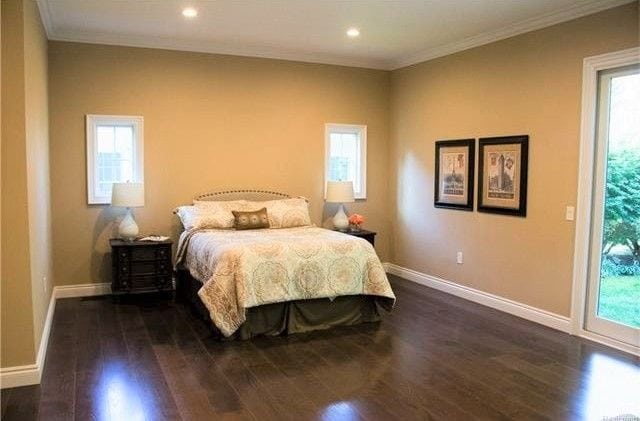 bedroom featuring multiple windows and dark hardwood / wood-style floors