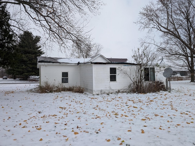 view of snow covered back of property