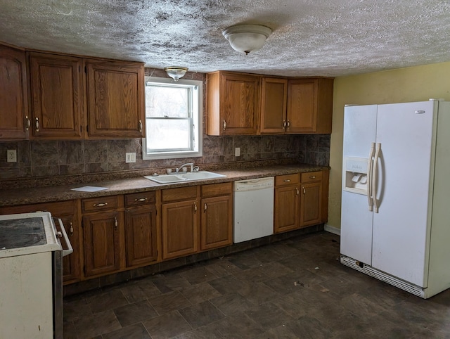 kitchen with a textured ceiling, white appliances, sink, and tasteful backsplash