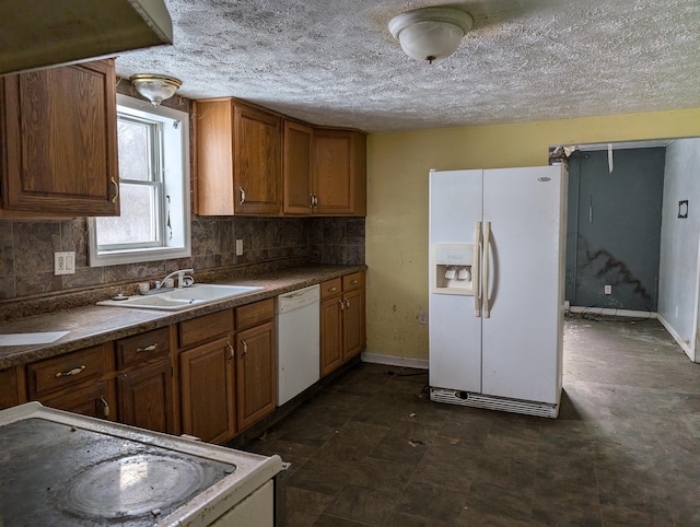 kitchen featuring a textured ceiling, white appliances, tasteful backsplash, and sink