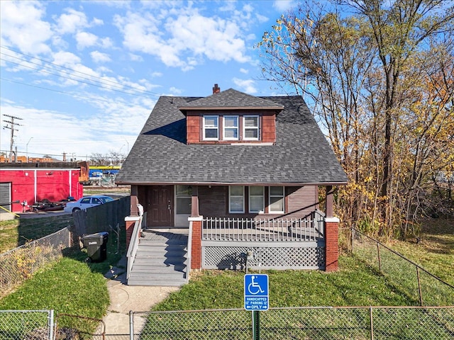 bungalow-style house featuring covered porch and a front yard