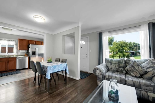 living room with a healthy amount of sunlight, dark hardwood / wood-style flooring, and sink