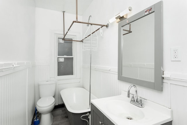 bathroom featuring a bathing tub, vanity, and toilet