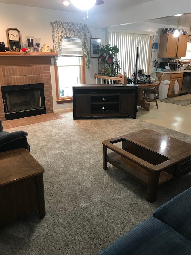 carpeted living room featuring a brick fireplace and ceiling fan